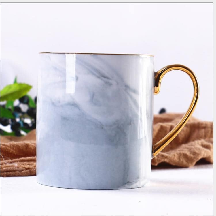 Keramisk kopp med marmormønster og gullhåndtak